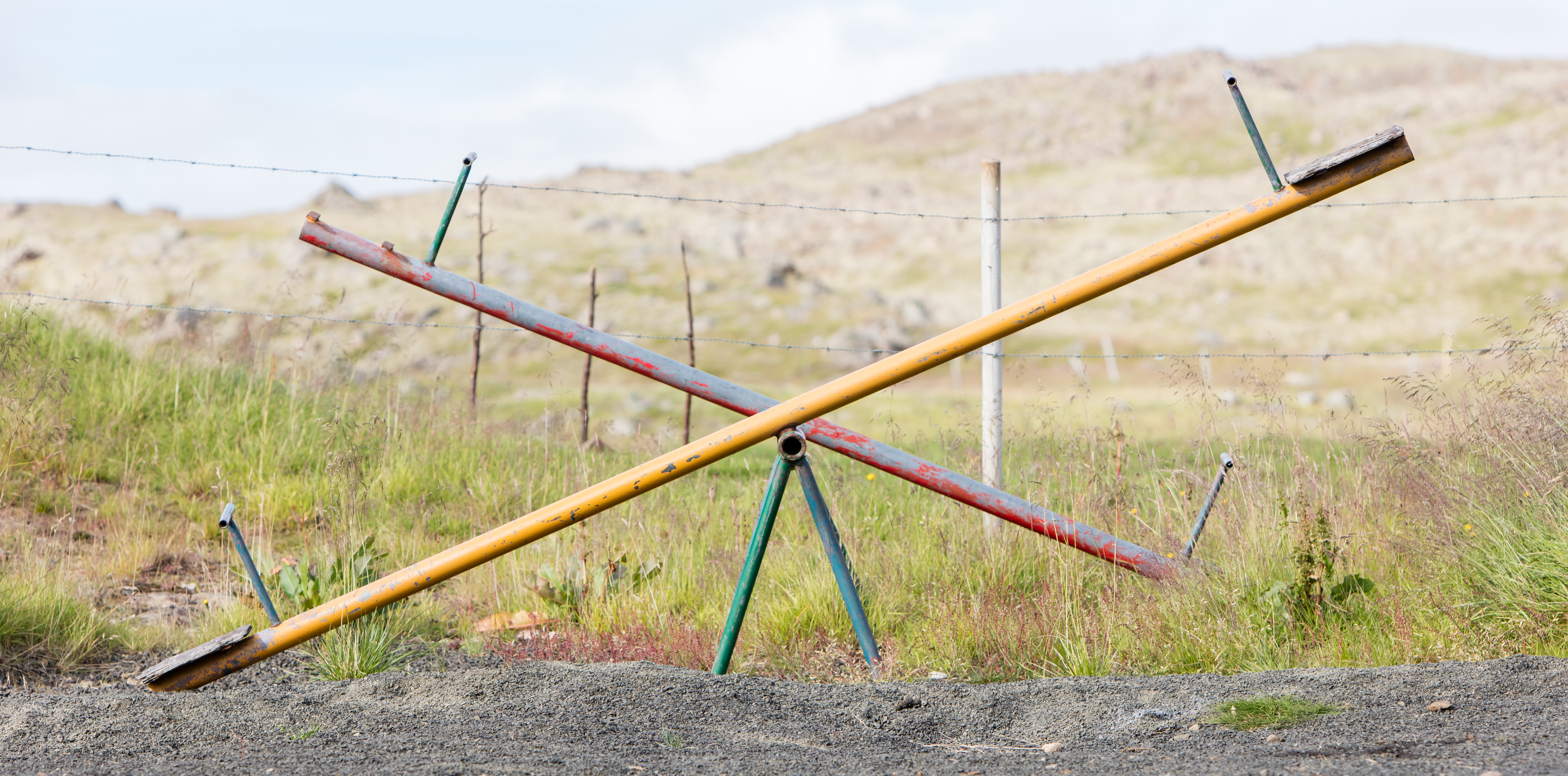 Old wooden and steel seesaw in the village playground
